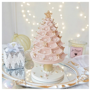 Detailed view of pink pleated Christmas tree music box with gold star and bow accents