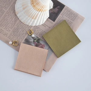 Flat lay of pink and olive velvet jewelry pouches with pearl earrings on vintage paper