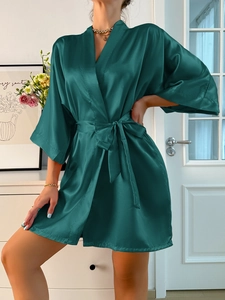 Détail du peignoir en satin de soie vert émeraude avec ceinture et texture lisse soyeuse