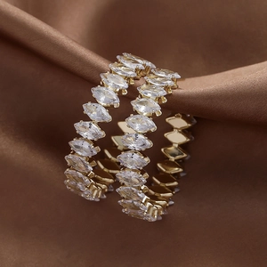 Close-up of vintage gold hoop earrings with marquise crystals on brown silk fabric