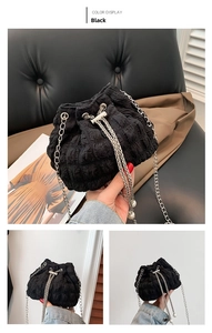 Detail of black pleated bucket bag with silver chain strap and decorative pearl charm
