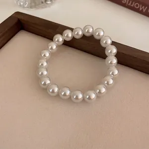 Elegant French vintage white pearl stretch bracelet on a warm textured background