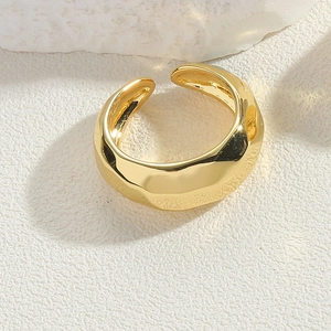 Close-up of 14K gold-plated cross ring with irregular fluid texture and adjustable band