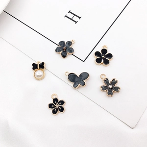 Flat lay of alloy charms with black enamel finish and gold accents for DIY jewelry making