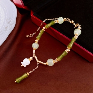 Bamboo style bracelet with green beads and white lily of the valley flower pendant