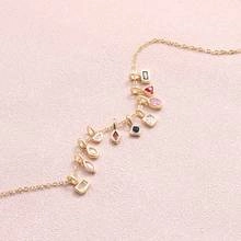 Detail of 18k gold titanium steel bracelet with colorful zircon geometric pendants