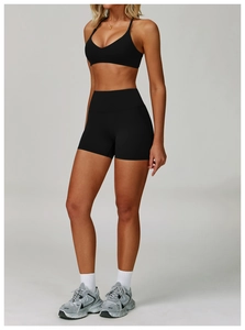 Detail of high-waist black yoga shorts and sports bra with a matte high-stretch fabric finish