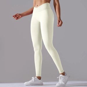 Detail view of seamless yoga pants showing the criss-cross high waistband and ivory fabric
