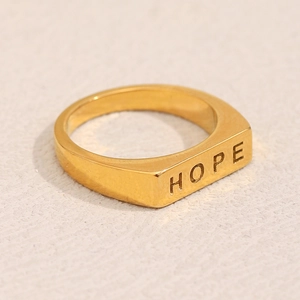 Nahaufnahme eines breiten 18K vergoldeten Edelstahl-Siegelrings mit HOPE-Gravur