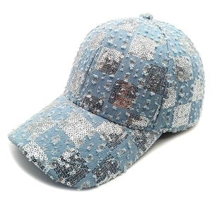 Detailed view of light blue denim baseball cap featuring silver sequins and frayed edges
