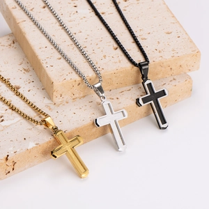 Three stainless steel cross necklaces in gold, silver and black colors on stone