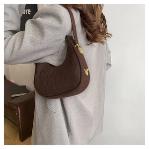 Chic brown felt crescent shoulder bag styled with a grey blazer for a modern look