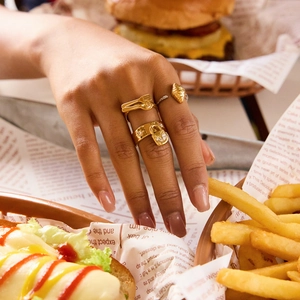 Détail de bagues en or 18 carats en forme de croissant et couverts sur une table
