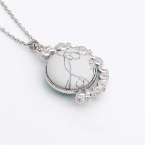 Macro shot of silver spinning pendant necklace with white marble and celestial moon patterns