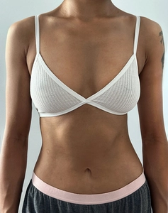 Gros plan d'une bralette triangle blanche en maille côtelée montrant la texture du tissu