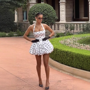 Robe dos nu élégante à pois blancs avec une coupe cintrée et une jupe volumineuse