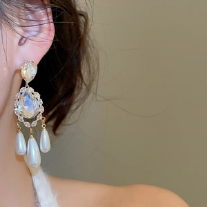 Detail of vintage teardrop pearl earrings with gold plating and zircon crystals