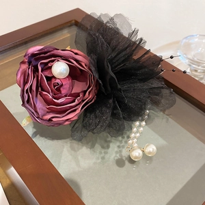 Detailed view of dark purple satin rose hair clip with lace and faux pearl tassels