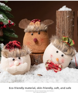 Macro detail of plush Christmas gift bags with Santa and Reindeer designs and red drawstrings