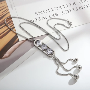 Silver long tassel necklace with zircon pendant over minimalist magazine background