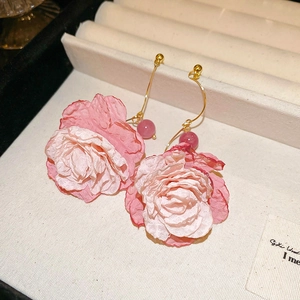 Detailed macro of pink gradient fabric flower earrings with gold hooks and beads