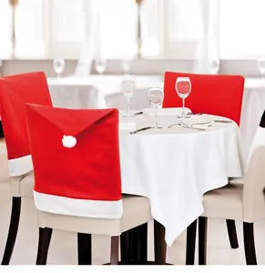 Detailed view of red Christmas hat chair covers with white plush pom-poms for party decor