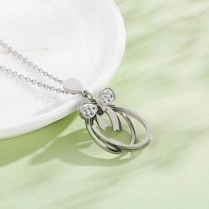 Detail of silver stainless steel necklace with hollow bow and rhinestone pendant