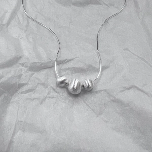 Collana minimalista in argento 925 con tre sfere satinate su una sottile catena a serpente