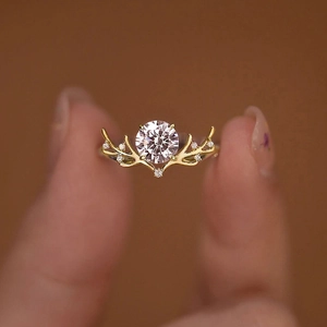 Squisito anello a corna di cervo in oro con un grande zircone rotondo incastonato