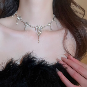 Detail of silver leaf necklace with crystal tassels on a black feather outfit