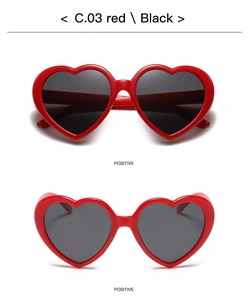 Detail view of red heart-shaped sunglasses with dark lenses and UV protection