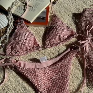 Macro view of pink tweed bikini set with metal rings and woven texture for summer