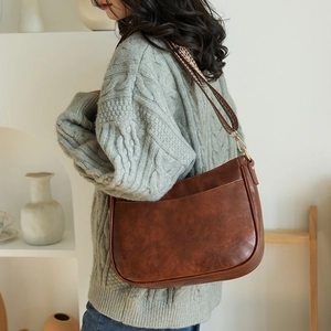 Dettaglio della borsa tote marrone vintage con tracolla in tessuto strutturato