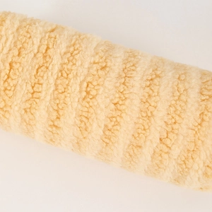 Close-up of the plush cream-colored sherpa fabric showing dense and soft woolly texture
