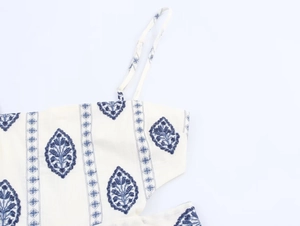 Detail of embroidered midi dress featuring blue ethnic patterns and delicate straps