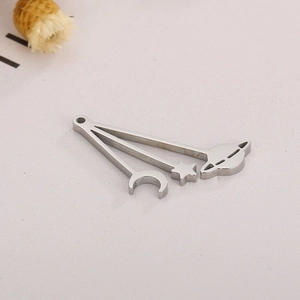 Detailed view of silver stainless steel moon star and saturn pendants on textured paper