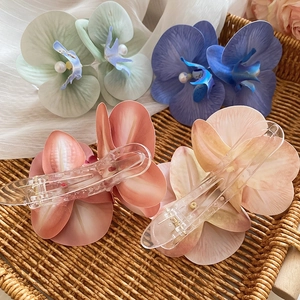 Detail of fabric flower hair clips with pearls and clear acrylic duckbill clips
