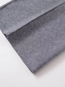 Détail du pantalon large en tricot gris chiné montrant la texture douce du tissu