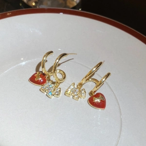 Macro detail of gold plated Scottish Terrier puppy earrings with red enamel heart charms