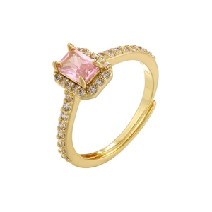 Close-up of gold-plated ring with pink rectangular gemstone and micro-pave crystals