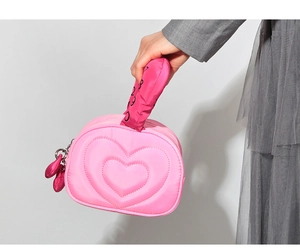 Vue détaillée du sac cosmétique matelassé cœur rose avec poignées imprimées co co