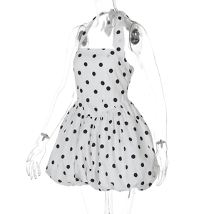 Detail of white halter neck mini dress with black polka dots and tiered bubble hemline