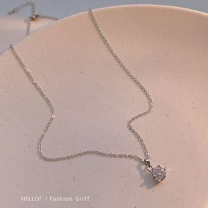 Vue macro du collier en acier titane argenté avec pendentif rond en zircon sur céramique