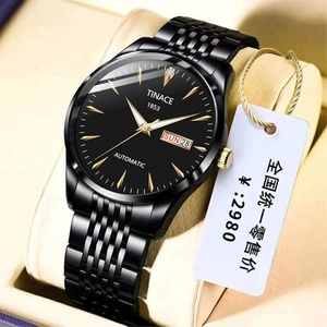 Detail of automatic mechanical watch with black dial and golden hands on leather stand
