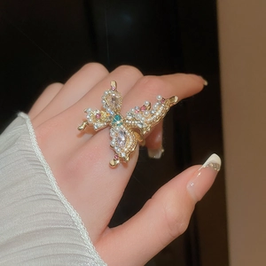 Detail of vintage butterfly ring with pearls and colorful zircons on gold base