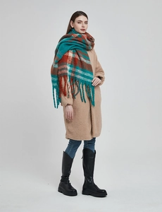 Close-up of thick plaid scarf with turquoise and orange checks and tassel details