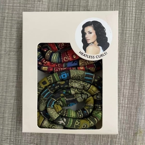 Top view of heatless hair curlers with ethnic patterns in a white window display box