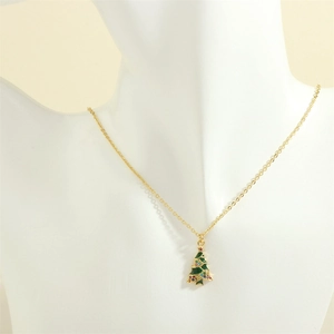 Close-up of a gold necklace with a green enamel Christmas tree pendant and colorful rhinestones