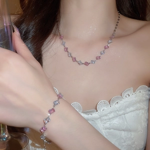 Close-up of elegant pink and white zircon necklace and bracelet set on a female model