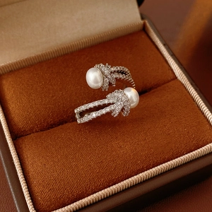 Macro detail of knotted pearl ring with zircon inlays on a velvet jewelry box
